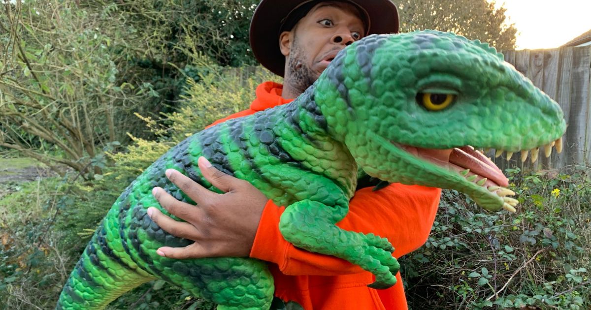 A handler holds a green T-Rex dinosaur at Dinosaur Days, The Beacon Eastbourne