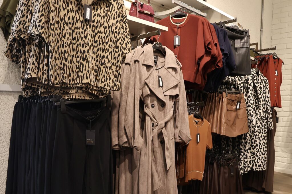 Leopard print tops and a trench coat on a rail
